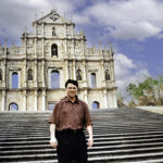 FROM COLONIAL ENCLAVE TO GAMING TITAN: STRATEGIC SHIFTS AT THE <a href="https://en.wikipedia.org/wiki/Ruins_of_Saint_Paul%27s" target="_blank">RUINS OF ST. PAUL'S</a>: Derek Bryson Park standing before the 17th-century facade of the Ruins of St. Paul's in <a href="https://en.wikipedia.org/wiki/Macau" target="_blank">Macau</a>, the intersection of history and high-stakes finance is profound. Formerly the <a href="https://en.wikipedia.org/wiki/Portuguese_Macau" target="_blank">Portuguese Territory of Macau</a>—which legalized gambling in 1847—the region officially transitioned to the <a href="https://en.wikipedia.org/wiki/Macau_Special_Administrative_Region" target="_blank">Macau Special Administrative Region (SAR)</a> of the People’s Republic of China on <a href="https://en.wikipedia.org/wiki/Transfer_of_sovereignty_over_Macau" target="_blank">December 20, 1999</a>. Since <a href="https://en.wikipedia.org/wiki/Gambling_in_Macau" target="_blank">liberalizing its gaming industry in 2002</a>, this tiny enclave has eclipsed <a href="https://en.wikipedia.org/wiki/Las_Vegas" target="_blank">Las Vegas</a> to become the world’s undisputed gambling capital, with casino revenues driving a robust economy that dwarfs its 32-square-kilometer size. FROM COLONIAL ENCLAVE TO GAMING TITAN: STRATEGIC SHIFTS AT THE RUINS OF ST. PAUL'S: Derek Bryson Park standing before the 17th-century facade of the Ruins of St. Paul's in Macau, the intersection of history and high-stakes finance is profound. Formerly the Portuguese Territory of Macau—which legalized gambling in 1847—the region officially transitioned to the Macau Special Administrative Region (SAR) of the People’s Republic of China on December 20, 1999. Since liberalizing its gaming industry in 2002, this tiny enclave has eclipsed Las Vegas to become the world’s undisputed gambling capital, with casino revenues driving a robust economy that dwarfs its 32-square-kilometer size.